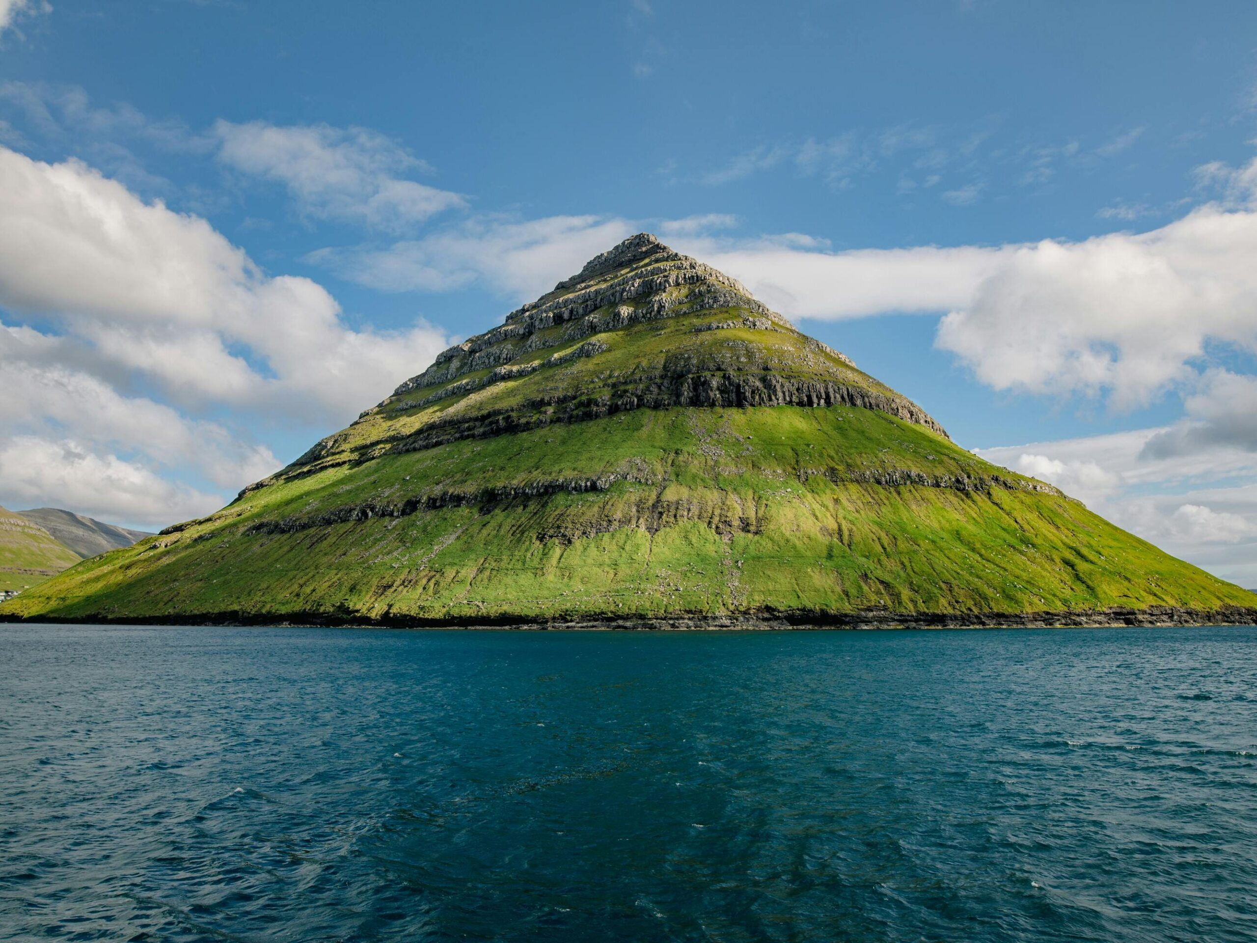 Stunning view of a mountain surrounded by the ocean in Klaksvík, Faroe Islands.